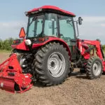Mahindra 2670 with cab compact utility tractor on dirt field.