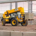 JCB 506-36 Telehandler transporting bricks on work site.