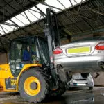 JCB 930 Rough Terrain Forklift lifting a car.