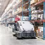 Advance CS7010 professional sweeper/scrubber cleaning warehouse floor.