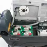 Advance SC750 scrubber, top lifted showing battery and fluids area.