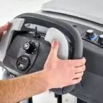 Advance SC901 scrubber, hands on operators handle.