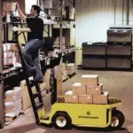 Operator climbing Columbia Stockchaser ladder to reach items in warehouse.