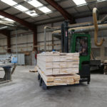 Combilift C Series C6000E electric forklift carrying lumber material.