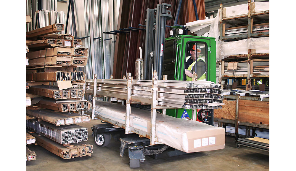 Combilift C Series C6000E electric forklift carrying materials in warehouse.