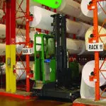 Combilift C6000 ST Stand On Multi-Directional Forklift in paper warehouse.