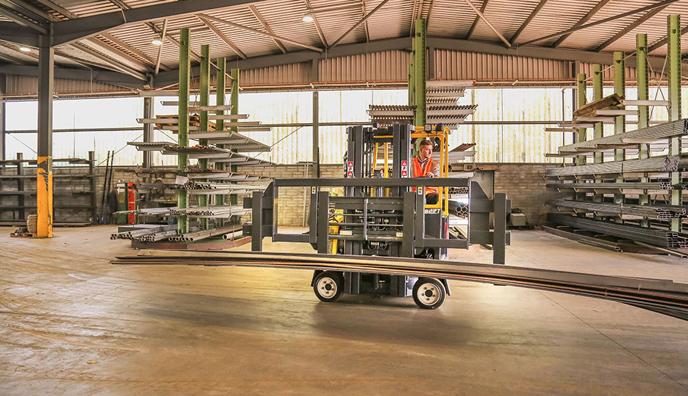Combilift COMBI-CB Forklift transporting long steel slabs in specialty metals and steel industry.