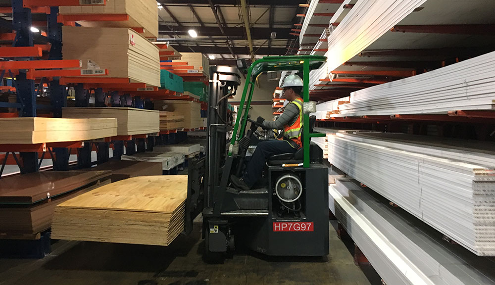 Combilift COMBI-CB Forklift carrying wood in lumber warehouse.