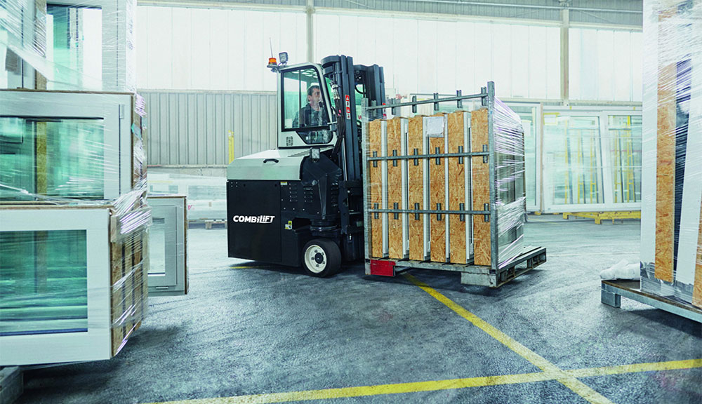Combilift COMBI-CB8E Electric Forklift carrying vinyl, siding and roofing supplies outdoors.