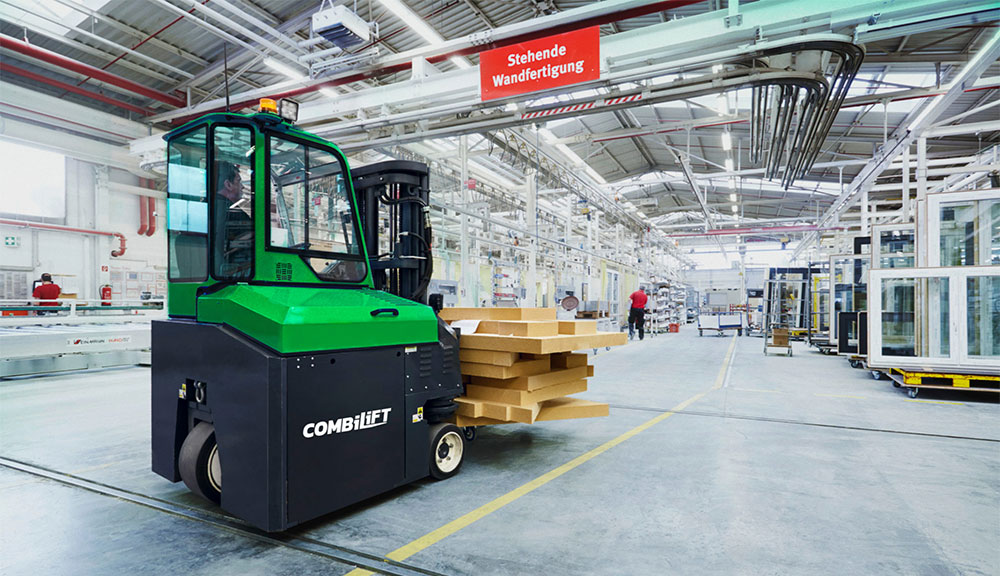 Combilift COMBI-CB8E Electric Forklift truck carrying wood in warehouse.