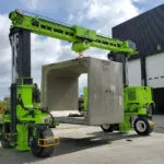 Combilift COMBI-MG Mobile Gantry Straddle Carrier carrying concrete outdoors.