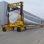 Combilift COMBI-MG Mobile Gantry Straddle Carrier carrying material.