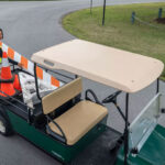Worker putting materials into Cushman Shuttle 2 Personnel Carrier cargo bed.