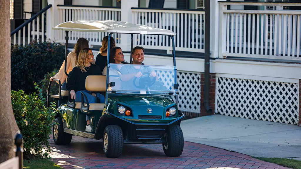 People in Cushman Shuttle 6 personnel vehicle.