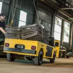 Worker stacking steel on Cushman Titan HD burden carrier cargo bed.