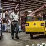Forklift loading beverage pallet onto Cushman Titan HD burden carrier deck.