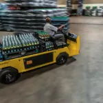 Cushman Titan HD burden carrier driving through beverage facility with loaded cargo deck.