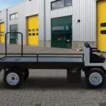 Side view of white and black Columbia Custom Platform utility vehicle outdoors, with custom rails on bed.