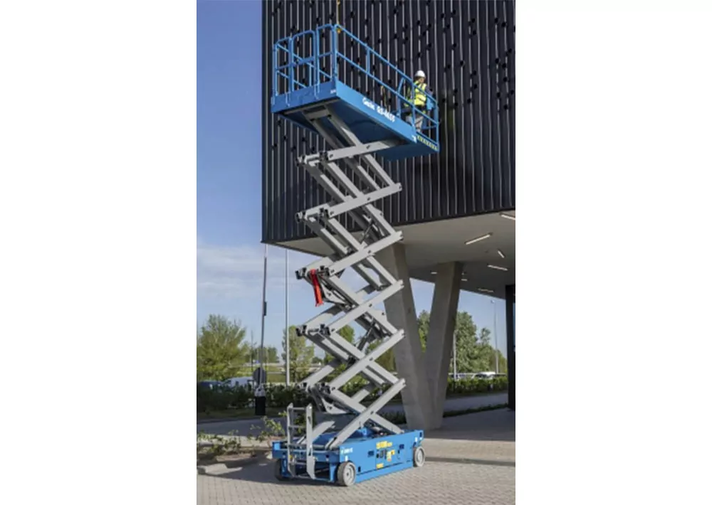 Genie GS-4655 raised to building with worker in bucket.