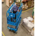 Genie GS-1930 scissor lift moving around corner in warehouse.