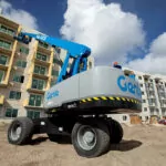Genie S-85 HF telescopic boom lift raising employees to repair the side of building.