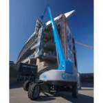 Back of Genie SX-135 XC boom lift with workers raised in the bucket.