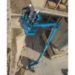 Genie SX-150 boom lift with workers raised in bucket.