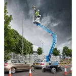 Operator in Genie Z-33/18 boom lift replacing street light.