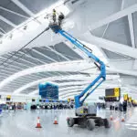 Genie Z-33/18 articulating boom lift raising operator to repair airport ceiling.