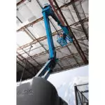 Genie Z-40/23 N boom lift raising operator to warehouse ceiling.