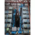 two Genie Z-40/23 articulating boom lifts in warehouse aisle.