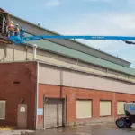 two operators being raised to building roof in Genie Z-62/40 boom lift.