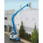 Operator being lifted to building roof in Genie Z-80/60 boom lift.