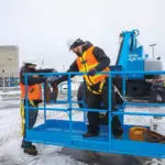 Operators in Genie ZX-135/70 boom lift bucket.