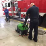 Firefighter cleaning garage floor with IPC Eagle CT45 walk-behind scrubber.