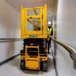 JCB 1930E electric scissor lift going through a hallway.