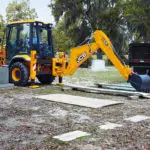 JCB 3CX Compact Backhoe Loader in a graveyard, side view.