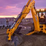 JCB 4CX Backhoe Loader digging dirt on building site.