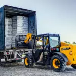 JCB 505-20TC Tool Carrier Telehandler unloading pallets from trailer.