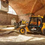 JCB 505-20E Telescopic Handler moving materials at indoor construction site.
