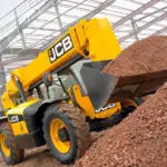 JCB 506-36 Telescopic Handler dumping dirt and stones on construction work site.