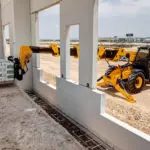 JCB 508-66TC loadall placing materials inside building on work site.