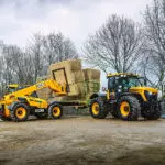 JCB 538-60 AGRI telehandler loading hay onto a trailer.