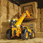 JCB 538-60 AGRI telescopic handler stacking hay in a barn.