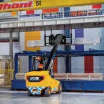 JCB 66-40E electric teletruk stacking metal in indoor shop.