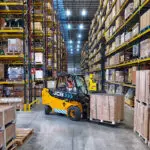 JCB 66-40E electric teletruk moving pallet in warehouse.