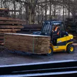 JCB 77-52D diesel teletruk carrying lumber.
