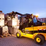 JCB 77-52D diesel teletruk stacking pallet of goods.