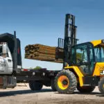 JCB 940 rough terrain forklift placing lumber on a truck trailer.