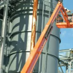 Worker providing maintenance with JLG 1200SJP ultra series telescopic boom lift.